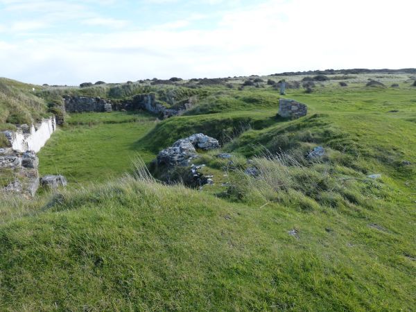 St-Piran's Oratory. Restant van de kluizenarij van St Piran in de duinen bij Perranporth. Op achtergrond recht: eeuwenoud Keltisch kruis dat de plek markeert.