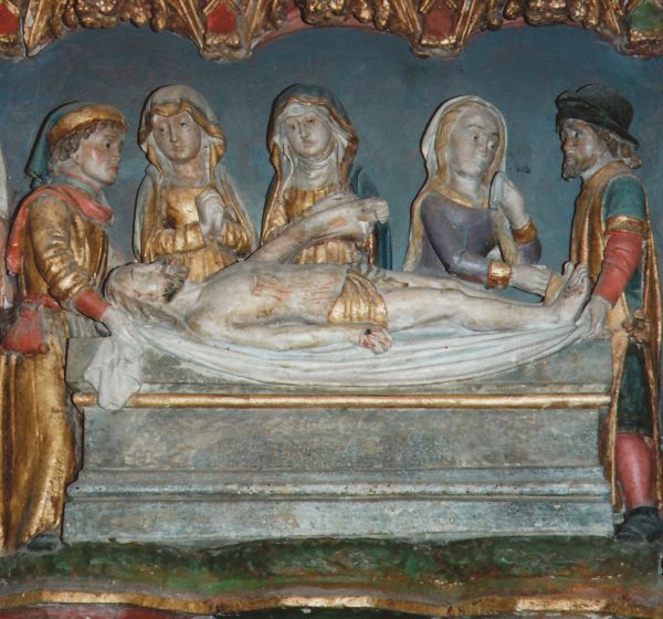Boven de sarcofaag, precies over de middenas van deze afbeelding, zien we de dode Jezus, in zijn volle lengte uitgestrekt op een laken dat aan weerszijden gedragen wordt door twee mannen: Nicodemus en Jozef van Arimatea. Daarachter - ten halve weergegeven - de drie vrouwen, die alle drie Maria heten. Alle vijf de personen reiken tot dezelfde hoogte, alsof daarmee gezegd wil worden dat zij gelijk zijn in het verdriet. De ruimte tussen de personen is nagenoeg gelijk: ze zijn evenredig over de lengte verdeeld. Dat geeft, ondanks het uitgebeelde lijden, een grote eenheid, harmonie en kalmte aan dit tafereel. Het verband tussen deze vijf mensen wordt gevormd door de overleden Jezus. Ieder van hen is op de een of andere manier op Hem betrokken. Tegelijk valt op hoe ieder wordt bezig gehouden door de eigen gevoelens. Als Jozef van Arimatea inderdaad te herkennen is aan zijn beurs, dan moet hij wel de linkse man zijn. Hij kocht het lijnwaad waarin Jezus nu rust.