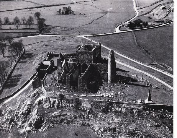 Luchtfoto van de ruïnes van Cashel. Tot 12e eeuw: zetel van de koningen van Munster, Ierland; sindsdien: kathedraal van bisdom Cashel. Ronde toren: 12e eeuw; ruïne kathedraal: 13e eeuw; romaanse kapel: 12e eeuw.