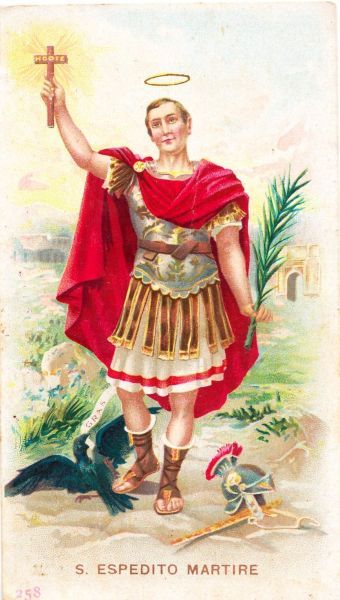 Aan Expeditus' voeten ligt zijn soldatenhelm. Linkerhand: palm; rechter: kruis met 'hodie'. Rechts van hem op de grond een spreuklint met de tekst 'Cras' ('morgen'). Dus: 'Niet morgen, maar vandaag nog!'.