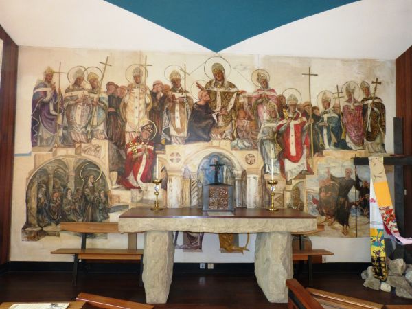 Alfege tussen de heiligen van Canterbury. De bisschop in het rode kazuifel rechts, met de erepalm van het martelaarschap. vóór 1979, Helen Grunwald, wandschildering.