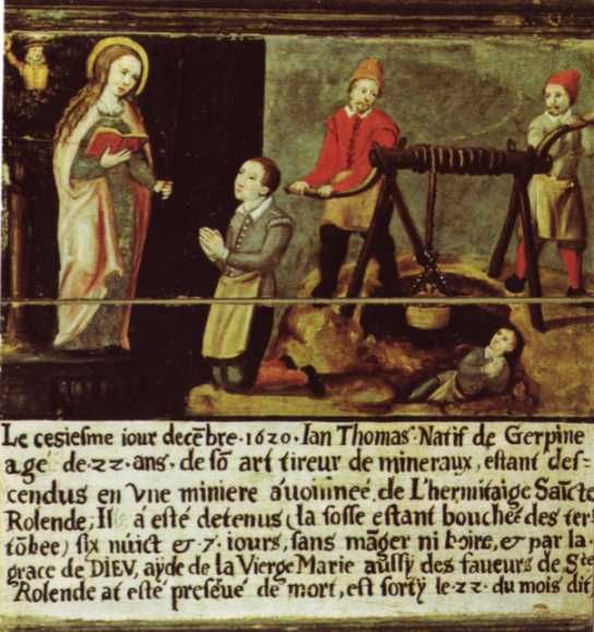 Het (vertaalde) onderschrift luidt: 'Op 16 december 1620 viel de 22-jarige Ian Thomas, inwoner van Gerpine en van beroep mijnwerker, in een gat vlakbij de kluizenaarscel van Sint Rolende. Daar heeft hij 7 dagen gelegen overdekt met aarde zonder eten of drinken. Door Gods genade, de hulp van de Maagd Maria en de Heilige Rolendis werd hij op de 22e van dezelfde maand gered van de dood.' .