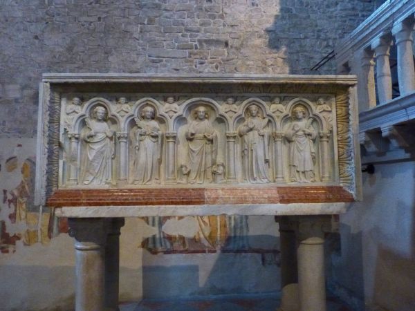 Centraal: Christus. Links van Christus (voor kijker rechts): Cantius en Cantianus. Rechts van Christus (voor kijker links): Cantianilla en Protus. ca 13e eeuw, steenreliëf.