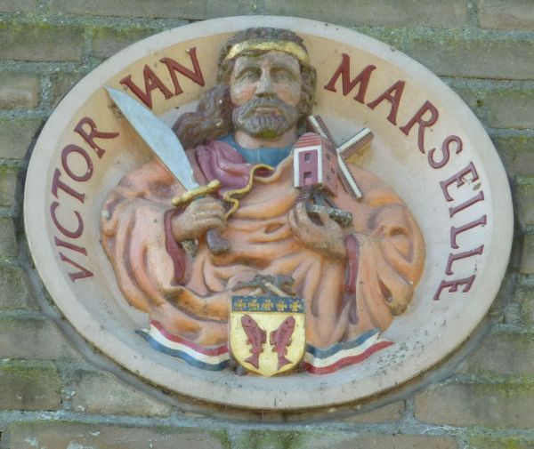 Deze gevelsteen verbeeldt de Beschermheilige van molenaars en vissers en is vervaardigd door Koos Boomstra. Hij werd onthuld door Dhr. R.H. Augustijn op 14 september 2002, en werd financieel mogelijk gemaakt door Rotaryclub Woudrichem