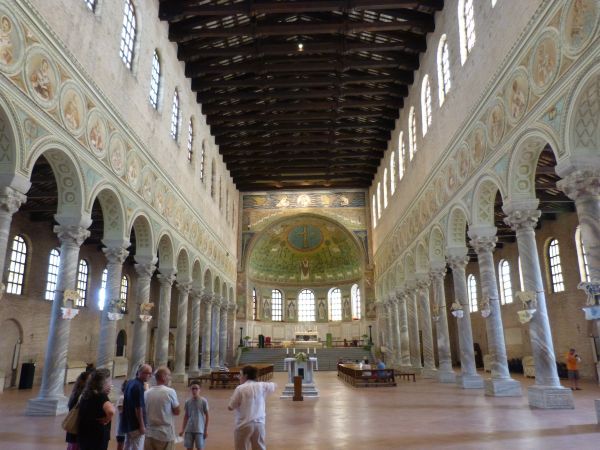 Interieur van de door Ursicinus gestichte Sant'Apollinare-in-Classe, Het mozaïek waarop Ursicinus zelf staat afgebeeld bevindt zich achter in de apsis onder de koepel met kruis tussen de ramen, de meest rechtse van de vier.