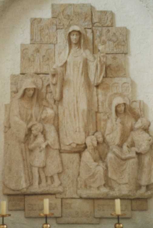 Lioba, Walburga en Thecla: de middelste als abdis; de eerste en de laatste als leermeesteressen. Muurreliëf in de abdijkerk te Münsterschwarzach; 20e eeuw. Eigen foto.
