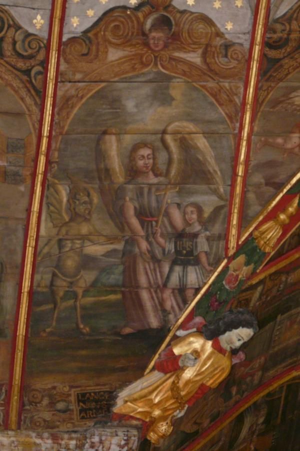 'L'ange qui nous arme' (de engel die ons wapent) We zien hoe de engel mij een kruis in de hand geeft, en mij daarmee wapent tegen de duivel. Deze staat dan ook machteloos terzijde met zijn speer doelloos in de hand, en de staart tussen de benen. Op mijn borst het Christusmonogram als kuras: IHS. De eerste drie Griekse letters van de naam Jezus. In het Latijn uitgelegd als de eerste letters van 'In Hoc Signo' (in dit teken), waarbij je moet aanvullen: 'zul je overwinnen'. Heel toepasselijk. Het lijkt zelfs wel of ikzelf een engelenvleugel krijg van deze 'wapens'.