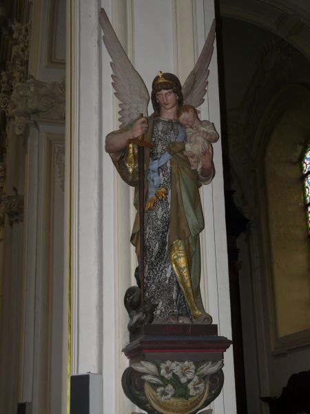 De engelbewaarder heeft in de rechtervuist een zwaard! Op linkerarm draagt hij een slapende kleuter. Heeft de kunstenaar gedacht aan Psalm 131: ' Als een gespeend kind bij zijn moeder; als dat gespeende kind: zo voelt in mij mijn ziel.'