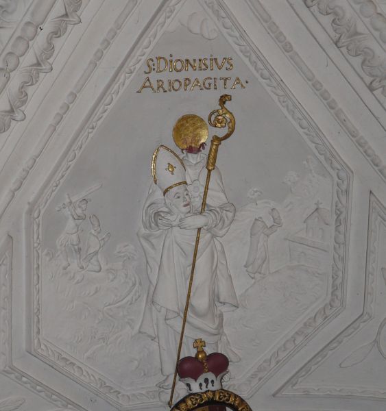 Mooi voorbeeld hoe Dionysius de Areopagiet wordt vereenzelvigd met de heilige Dionysius die het evangelie naar Parijs bracht (Saint-Denis). Op de achtergrond zien we hoe Saint Denis wordt onthoofd, en hoe hij zijn hoofd van de Mont-Martre (Martelarenberg) naar Saint-Denis brengt, waar hij zou worden begraven en waar de kerk nog steeds naar hem is genoemd. Op de voorgrond zien we hem met zijn hoofd in de handen. Op zijn hals is het heiligenkransje blijven staan!