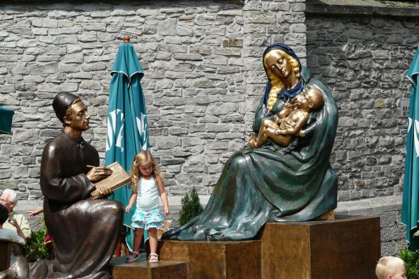 Voor de kathedraal van Doornik staat een sculptuur van Lukas die de Madonna schildert. Kinderen kunnen er op spelen.