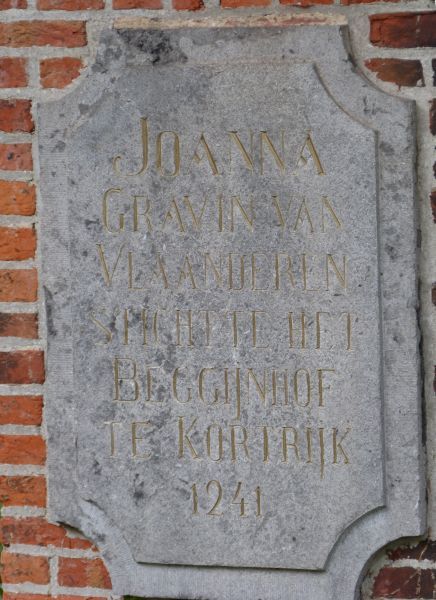 Herdeninkingsplaat op de sokkel van Johanna's beeld. 'Johanna, gravin van Vlaanderen, stichtte het Beggijnhof te Kortrijk, 1941'.