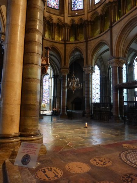 Waar het kaarsje brandt bevond zich de schrijn van Thomas Becket, toevluchtsoord van duizenden pelgrims in de Middeleeuwen (lees Canterburytales van Geoffrey Chaucer, eind 14e eeuw). De plek waar de aartsbisschop op last van de koning werd vermoord. Die plek is thans leeg, omdat de schrijn halverwege de 16e eeuw werd vernietigd, wederom op last van een koning: Hendrik VIII. Hoe geschiedenis zich herhaalt, in beeld gebracht door... een kaarsje in een lege ruimte.